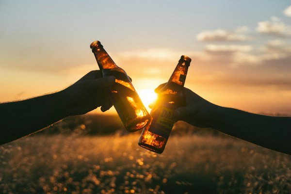 Botellines de cerveza brindando al atardecer
