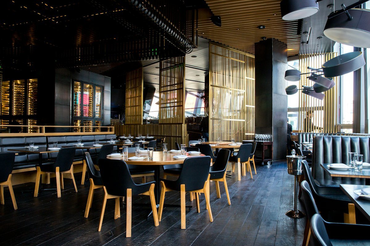 Salón con mesas de madera y luz baja