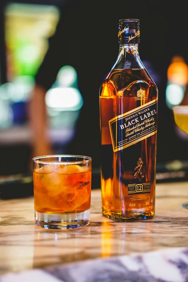 Botella de Johnnie Walker Black y vaso con hielo